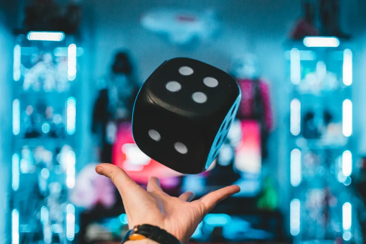  person's left palm about to catch black dice. Unsplash